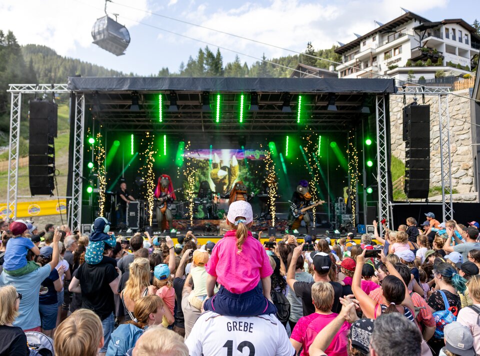 Menschenmenge genießt ein Live-Konzert mit bunten Lichtern.