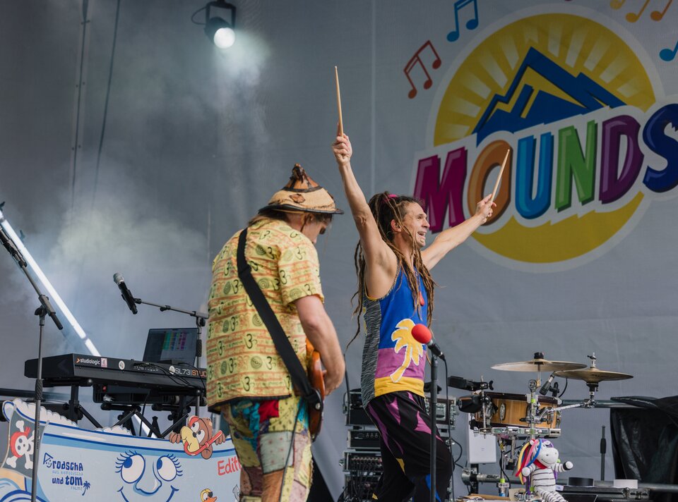 Musiker performen mit Farben und Freude auf der MOUNDS-Bühne.