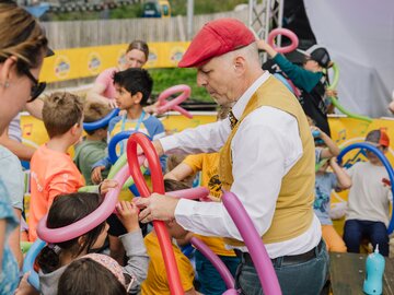 Kinder kreieren mit Luftballons zusammen mit einem unterhaltsamen Veranstalter.