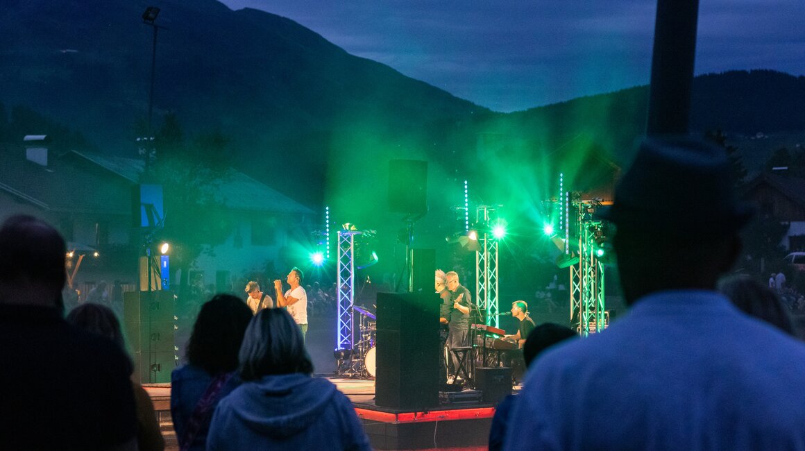 Ein Konzert am Wasser mit Lichtshow und Publikum im Hintergrund.
