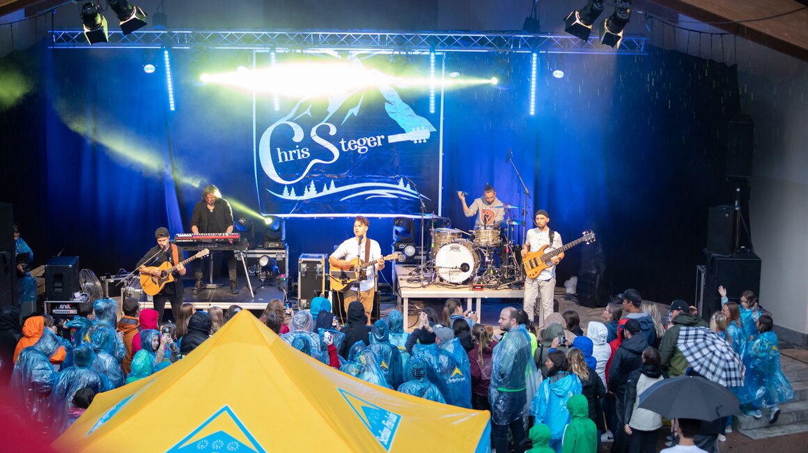 Chris Steger spielt live auf der Bühne vor Publikum und Zelt.